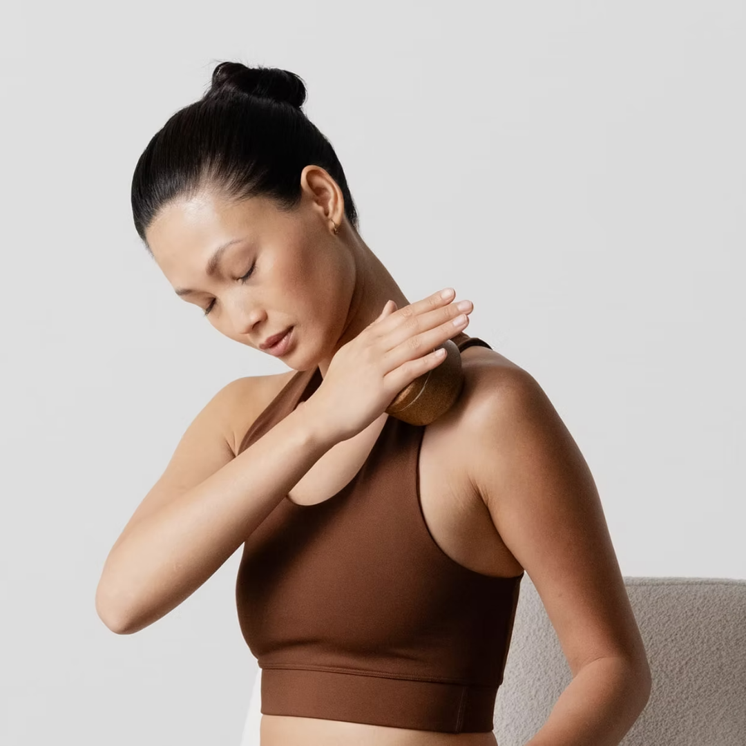 Women using the massage ball on her shoulders.