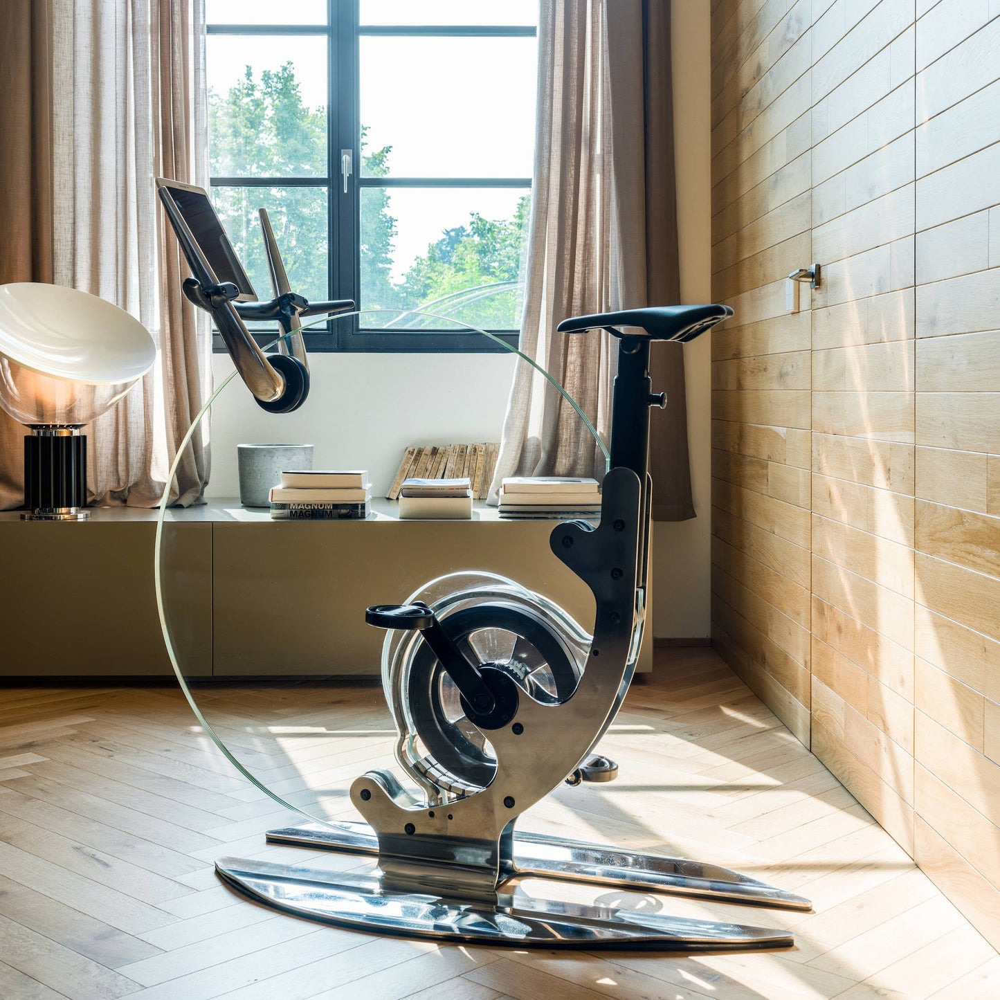 A luxurious gym equipment, Italian design exercise bike made of crystal glass placed at luxury hotel room. Ciclotte Teckell - Glass Exercise Bike