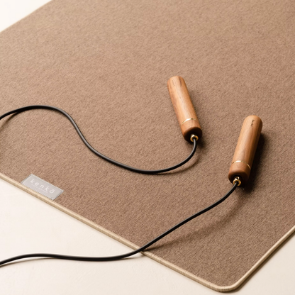 American walnut handle skipping rope with coiled natural rubber rope.