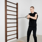 Man using a wall-mounted pull-up bar in a minimalistic room.