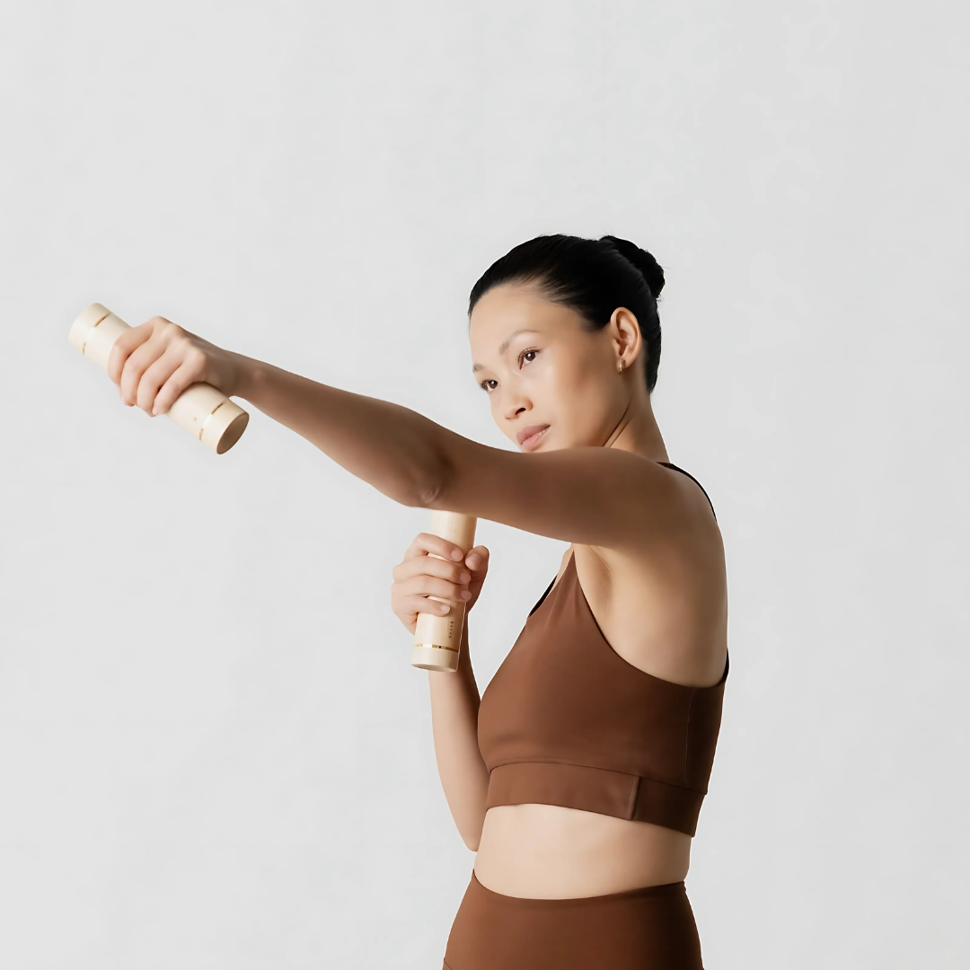 User performing light upper body exercises with maple-handled aerobic dumbbells.