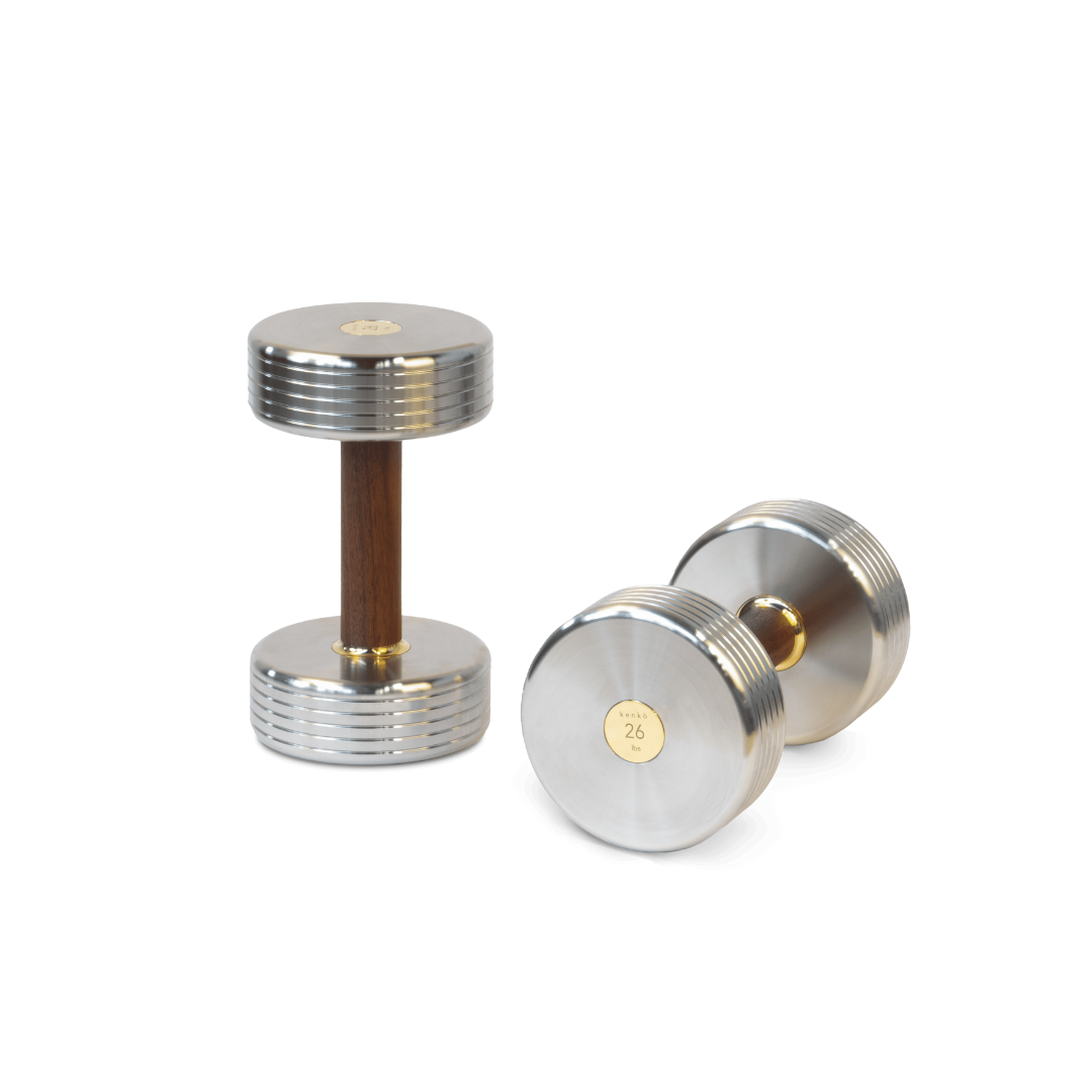 Premium dumbbell combining solid wood grip, polished steel, and gold-plated detailing.