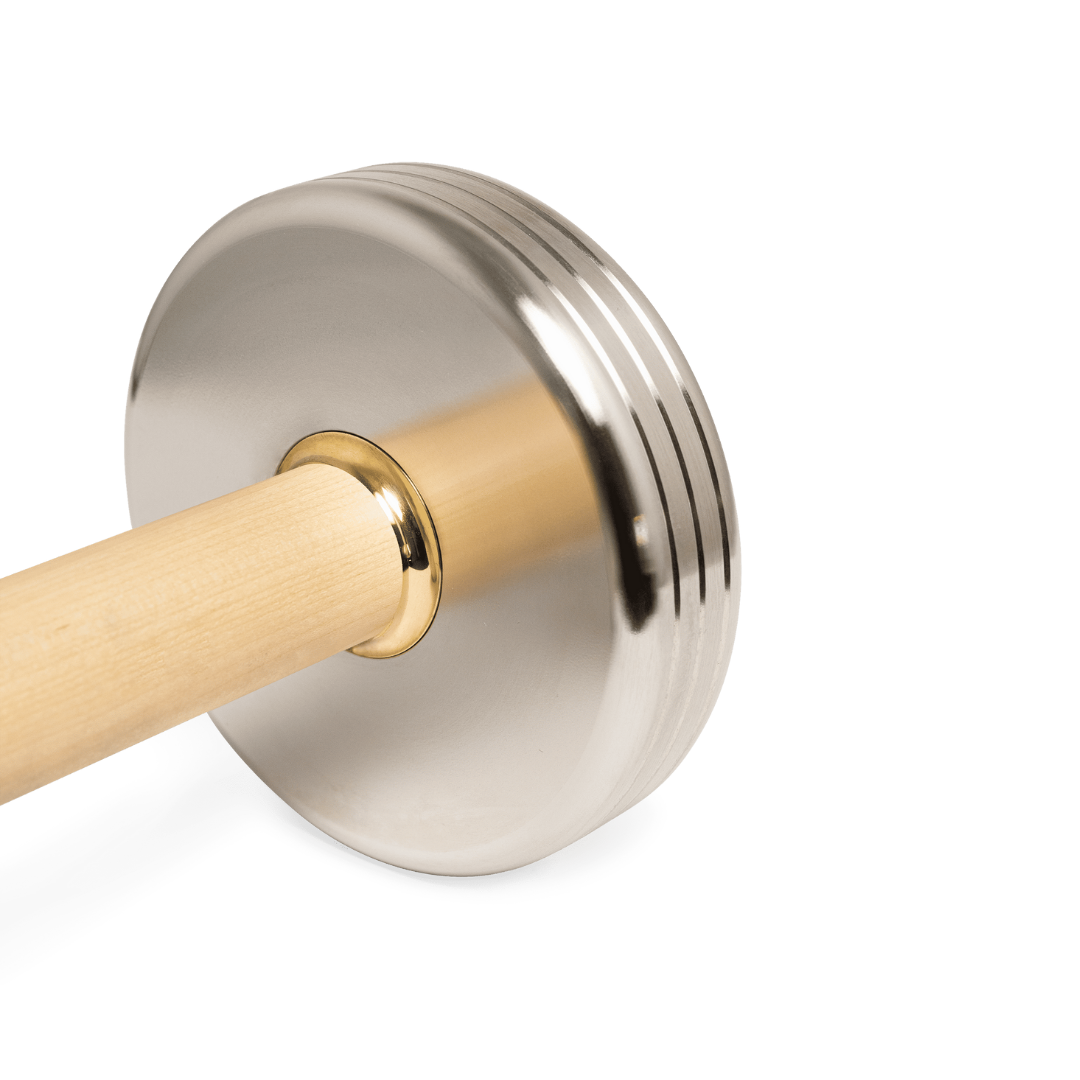 Close-up of maple handle with polished brass accent on stainless steel dumbbell.