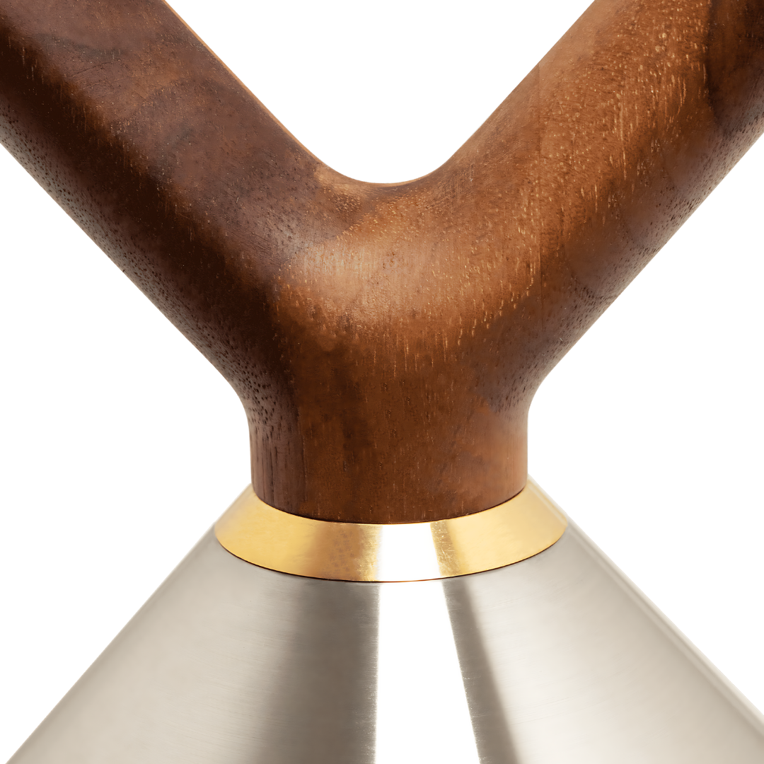 Close-up of walnut handle with brass accent on polished stainless steel kettlebell.