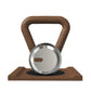 Luxury home gym equipment, premium kettlebell on wooden stand, made with stainless steel and natural walnut wood.