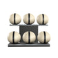 Six beige leather medicine balls with black accent leather, arranged on two shelves made of black ash wood. PENT. MOXA Set Ultimate - Set of 6 Medicine Balls on Horizontal Wooden Stand