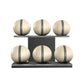 Six beige leather medicine balls with grey accent leather, arranged on two shelves made of black ash wood. PENT. MOXA Set Ultimate - Set of 6 Medicine Balls on Horizontal Wooden Stand