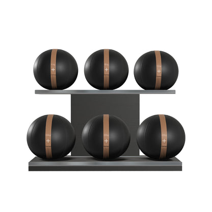 Six black leather medicine balls with brown accent leather, arranged on two shelves made of black ash wood. PENT. MOXA Set Ultimate - Set of 6 Medicine Balls on Horizontal Wooden Stand