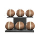 Six brown leather medicine balls with white accent leather, arranged on two shelves made of black ash wood. PENT. MOXA Set Ultimate - Set of 6 Medicine Balls on Horizontal Wooden Stand