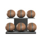 Six brown leather medicine balls with grey accent leather, arranged on two shelves made of black ash wood. PENT. MOXA Set Ultimate - Set of 6 Medicine Balls on Horizontal Wooden Stand