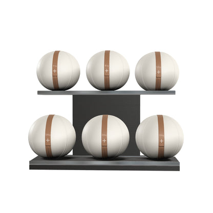 Six white leather medicine balls with brown accent leather, arranged on two shelves made of black ash wood. PENT. MOXA Set Ultimate - Set of 6 Medicine Balls on Horizontal Wooden Stand