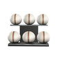Six white leather medicine balls with brown accent leather, arranged on two shelves made of black ash wood. PENT. MOXA Set Ultimate - Set of 6 Medicine Balls on Horizontal Wooden Stand