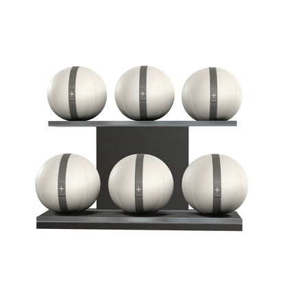 Six white leather medicine balls with grey accent leather, arranged on two shelves made of black ash wood. PENT. MOXA Set Ultimate - Set of 6 Medicine Balls on Horizontal Wooden Stand
