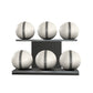 Six white leather medicine balls with grey accent leather, arranged on two shelves made of black ash wood. PENT. MOXA Set Ultimate - Set of 6 Medicine Balls on Horizontal Wooden Stand