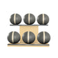 Six grey leather medicine balls with beige accent leather, arranged on two shelves made of natural ash wood. PENT. MOXA Set Ultimate - Set of 6 Medicine Balls on Horizontal Wooden Stand