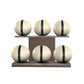 Six beige leather medicine balls with black accent leather, arranged on two shelves made of natural walnut wood. PENT. MOXA Set Ultimate - Set of 6 Medicine Balls on Horizontal Wooden Stand