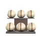 Six beige leather medicine balls with brown accent leather, arranged on two shelves made of natural walnut wood. PENT. MOXA Set Ultimate - Set of 6 Medicine Balls on Horizontal Wooden Stand
