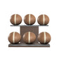 Six brown leather medicine balls with beige accent leather, arranged on two shelves made of natural walnut wood. PENT. MOXA Set Ultimate - Set of 6 Medicine Balls on Horizontal Wooden Stand