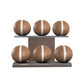 Six brown leather medicine balls with white accent leather, arranged on two shelves made of natural walnut wood. PENT. MOXA Set Ultimate - Set of 6 Medicine Balls on Horizontal Wooden Stand