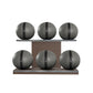 Six grey leather medicine balls with black accent leather, arranged on two shelves made of natural walnut wood. PENT. MOXA Set Ultimate - Set of 6 Medicine Balls on Horizontal Wooden Stand