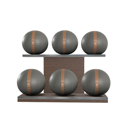 Six grey leather medicine balls with brown accent leather, arranged on two shelves made of natural walnut wood. PENT. MOXA Set Ultimate - Set of 6 Medicine Balls on Horizontal Wooden Stand