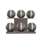 Six grey leather medicine balls with white accent leather, arranged on two shelves made of natural walnut wood. PENT. MOXA Set Ultimate - Set of 6 Medicine Balls on Horizontal Wooden Stand