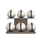 Six white leather medicine balls with black accent leather, arranged on two shelves made of natural walnut wood. PENT. MOXA Set Ultimate - Set of 6 Medicine Balls on Horizontal Wooden Stand