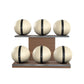 Six beige leather medicine balls with black accent leather, arranged on two shelves made of natural walnut wood. PENT. MOXA Set Ultimate - Set of 6 Medicine Balls on Horizontal Wooden Stand