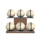 Six beige leather medicine balls with grey accent leather, arranged on two shelves made of natural walnut wood. PENT. MOXA Set Ultimate - Set of 6 Medicine Balls on Horizontal Wooden Stand