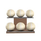 Six beige leather medicine balls with beige accent leather, arranged on two shelves made of natural walnut wood. PENT. MOXA Set Ultimate - Set of 6 Medicine Balls on Horizontal Wooden Stand