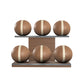 Six brown leather medicine balls with beige accent leather, arranged on two shelves made of natural walnut wood. PENT. MOXA Set Ultimate - Set of 6 Medicine Balls on Horizontal Wooden Stand