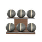 Six grey leather medicine balls with beige accent leather, arranged on two shelves made of natural walnut wood. PENT. MOXA Set Ultimate - Set of 6 Medicine Balls on Horizontal Wooden Stand