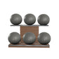 Six grey leather medicine balls with grey accent leather, arranged on two shelves made of natural walnut wood. PENT. MOXA Set Ultimate - Set of 6 Medicine Balls on Horizontal Wooden Stand