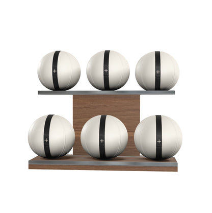 Six white leather medicine balls with black accent leather, arranged on two shelves made of natural walnut wood. PENT. MOXA Set Ultimate - Set of 6 Medicine Balls on Horizontal Wooden Stand