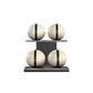Four beige leather medicine balls with black accent leather, arranged on two shelves made of black ash wood. PENT. MOXA Power - Set of 4 Medicine Balls on Horizontal Wooden Stand