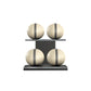 Four beige leather medicine balls with grey accent leather, arranged on two shelves made of black ash wood. PENT. MOXA Power - Set of 4 Medicine Balls on Horizontal Wooden Stand