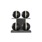 Four black leather medicine balls with beige accent leather, arranged on two shelves made of black ash wood. PENT. MOXA Power - Set of 4 Medicine Balls on Horizontal Wooden Stand