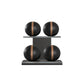 Four black leather medicine balls with brown accent leather, arranged on two shelves made of black ash wood. PENT. MOXA Power - Set of 4 Medicine Balls on Horizontal Wooden Stand
