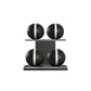 Four black leather medicine balls with white accent leather, arranged on two shelves made of black ash wood. PENT. MOXA Power - Set of 4 Medicine Balls on Horizontal Wooden Stand