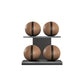 Four brown leather medicine balls with black accent leather, arranged on two shelves made of black ash wood. PENT. MOXA Power - Set of 4 Medicine Balls on Horizontal Wooden Stand