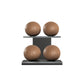 Four brown leather medicine balls with brown accent leather, arranged on two shelves made of black ash wood. PENT. MOXA Power - Set of 4 Medicine Balls on Horizontal Wooden Stand