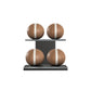 Four brown leather medicine balls with white accent leather, arranged on two shelves made of black ash wood. PENT. MOXA Power - Set of 4 Medicine Balls on Horizontal Wooden Stand