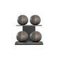 Four black leather medicine balls with brown accent leather, arranged on two shelves made of black ash wood. PENT. MOXA Power - Set of 4 Medicine Balls on Horizontal Wooden Stand