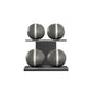 Four grey leather medicine balls with white accent leather, arranged on two shelves made of black ash wood. PENT. MOXA Power - Set of 4 Medicine Balls on Horizontal Wooden Stand