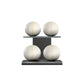 Four white leather medicine balls with beige accent leather, arranged on two shelves made of black ash wood. PENT. MOXA Power - Set of 4 Medicine Balls on Horizontal Wooden Stand