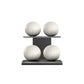 Four white leather medicine balls with white accent leather, arranged on two shelves made of black ash wood. PENT. MOXA Power - Set of 4 Medicine Balls on Horizontal Wooden Stand