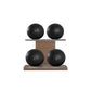 Four black leather medicine balls with black accent leather, arranged on two shelves made of natural walnut wood. PENT. MOXA Power - Set of 4 Medicine Balls on Horizontal Wooden Stand