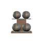 Four grey leather medicine balls with brown accent leather, arranged on two shelves made of natural walnut wood. PENT. MOXA Power - Set of 4 Medicine Balls on Horizontal Wooden Stand