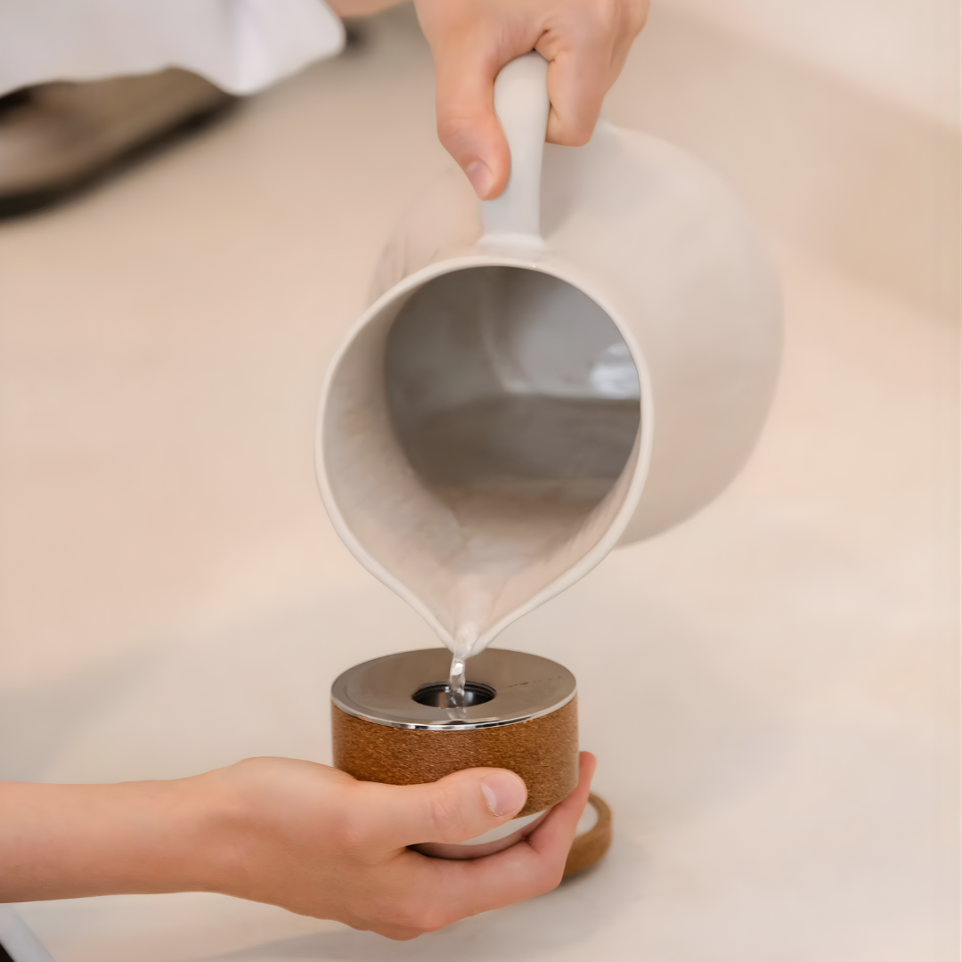 Person pouring liquid into massage ball with cork base.