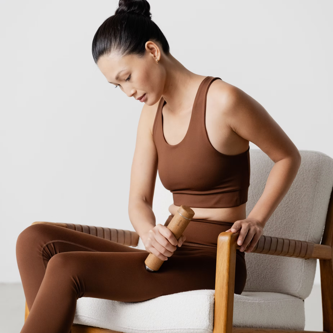 Woman  using massage stick to massage her le.